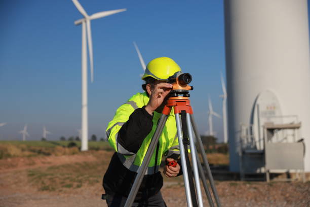 istock Energy engineer using a survey camera to measure elevation in a wind turbine farm for electricity production, emphasizing green energy initiatives. 2194299975