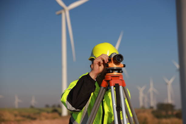 istock Energy engineer using a survey camera to measure elevation in a wind turbine farm for electricity production, emphasizing green energy initiatives. 2194299981