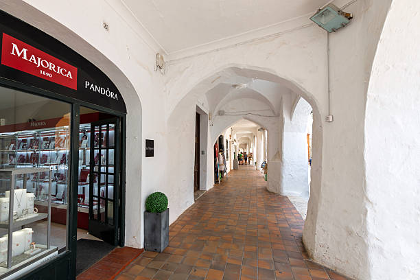 A covered walkway colonnade portico and arcade with arched whitewashed interior in the historic center of Ciutadella de Menorca, Spain, on the Balearic island of Menorca in the Mediterranean Sea.
