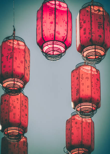 istock Crimson lanterns, hanging against a muted sky, create a visually stunning display of traditional craftsmanship and festive ambiance.  Their intricate designs and soft glow hint at a cultural celebration. 2194300543