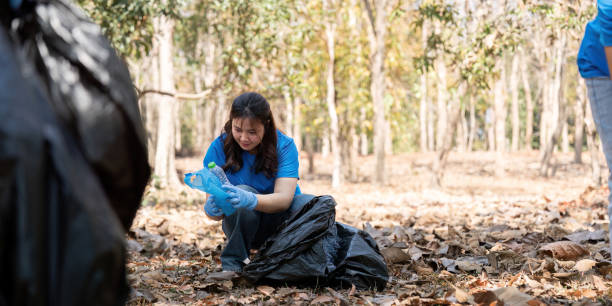istock Volunteer collecting plastic waste in a forest, emphasizing environmental responsibility and community action 2194300602