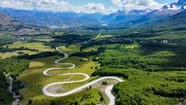 Road Trip on the Carretera Austral in the Cerro Castillo Region, Chilean Patagonia Aerial view of a winding road on the Carretera Austral, crossing green fields and dense forests in the stunning Cerro Castillo region, Chilean Patagonia. This is one of the most iconic stretches for a road trip, offering breathtaking landscapes of snow-capped mountains, lush valleys, and pristine nature. A must-visit destination for adventurers and travel enthusiasts. carretera austral chile stock pictures, royalty-free photos & images