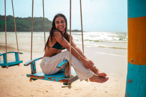 istock Joyful Hispanic Woman Relaxing on Beach Swing 2194301431