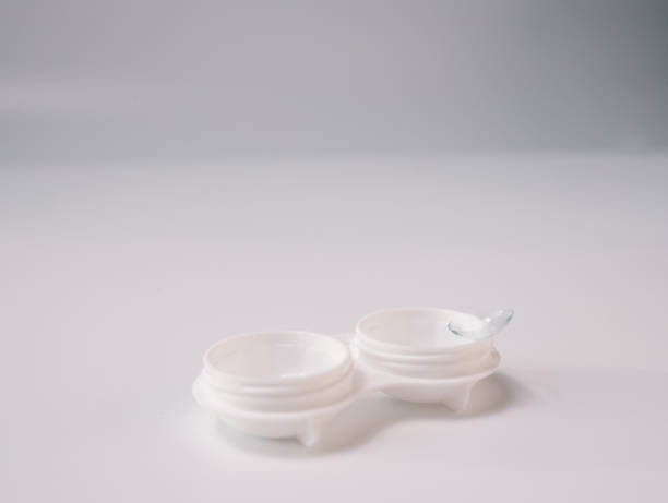 istock White contact lens case with a transparent lens on one side, placed on a clean white background. Minimalist design representing vision correction, hygiene, and eye care essentials 2194325470
