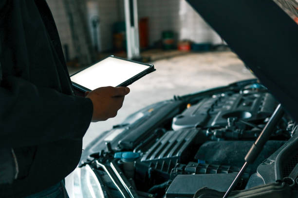 istock A mechanic holding a tablet while inspecting a car engine in a workshop. The focus is on the integration of modern technology in vehicle diagnostics and repair 2194327361