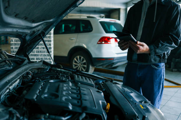 istock A mechanic holding a tablet while inspecting a car engine in a workshop. The focus is on the integration of modern technology in vehicle diagnostics and repair 2194327369