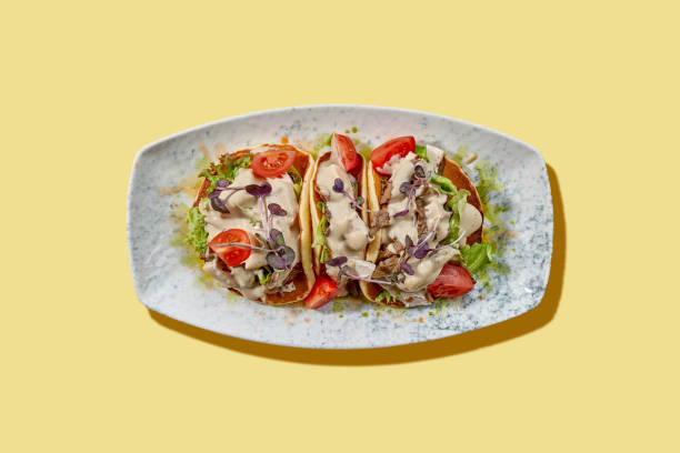 istock A vibrant and colorful gourmet taco featuring tender pulled pork, fresh greens, and a drizzle of tangy barbecue sauce. 2194330737