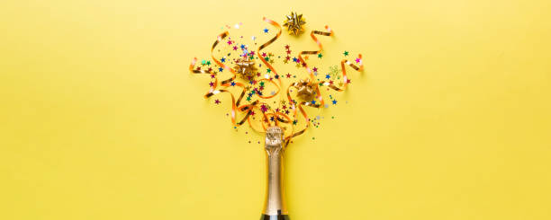 istock Creative flat lay composition with bottle of champagne and space for text on color background. Champagne bottle with colorful party streamers. holiday or christmas concept 2194334702