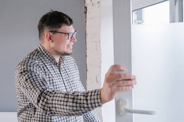 istock man cleaning a window at home. spring cleaning. 2194336159