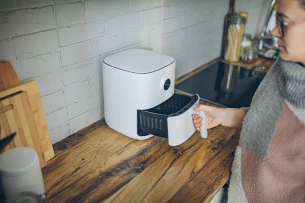 istock Woman using air fryer in kitchen 2194336293