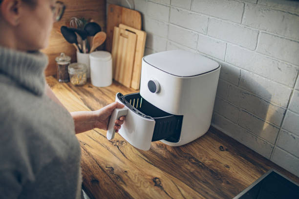 istock Woman using air fryer in kitchen 2194336314