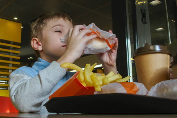 istock Boy eating aburger at cafe, lower view 2194337594