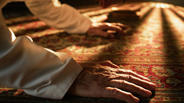 istock Man Prays For Ramadan On Carpet During Sunny Day 2194338876