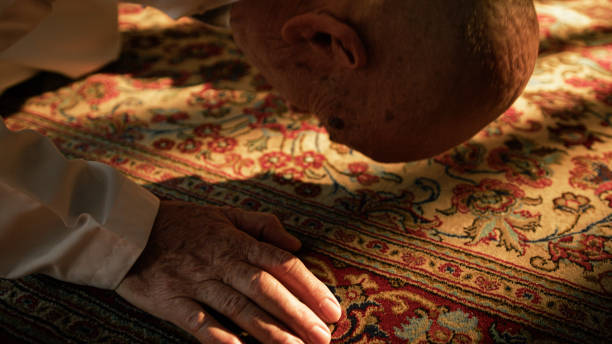 istock Man Prays For Ramadan On Carpet During Sunny Day 2194338890