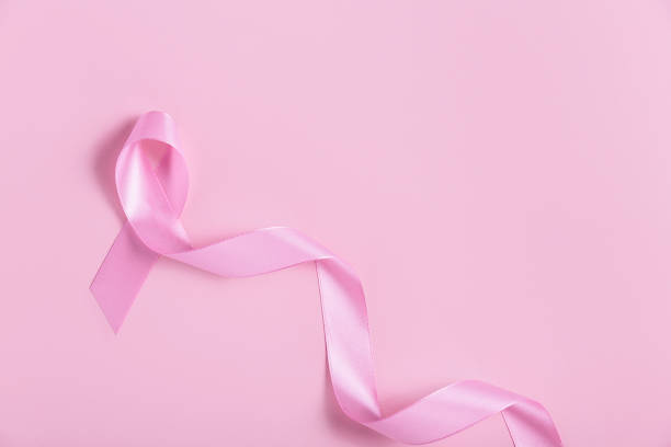 istock Pink breast cancer ribbon on pink background 2194342459