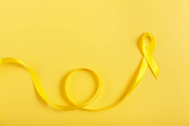 A simple yet impactful image of a yellow ribbon lying on a bright yellow background, symbolizing bladder cancer awareness. Ideal for healthcare campaigns, charity events, and awareness initiatives.