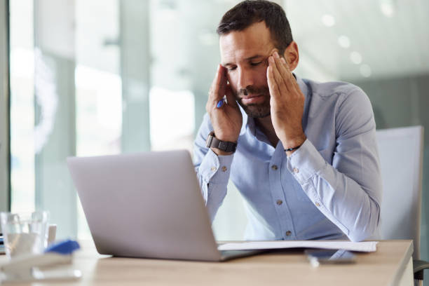 istock Male entrepreneur with a headache working on laptop in the office. 2194342918
