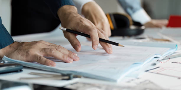 istock Architects Planning Modern House Construction with Blueprints and Tools on Desk 2194345255