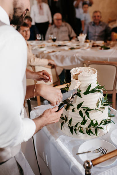 istock newlyweds happily cut and taste the wedding cake 2194348353