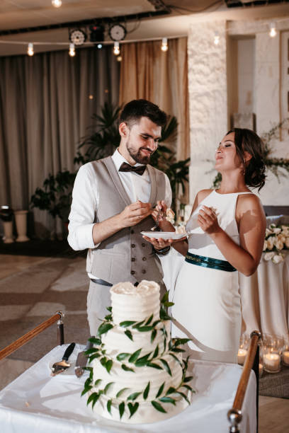 istock newlyweds happily cut and taste the wedding cake 2194348812