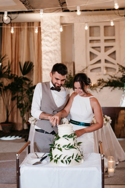 istock newlyweds happily cut and taste the wedding cake 2194349444