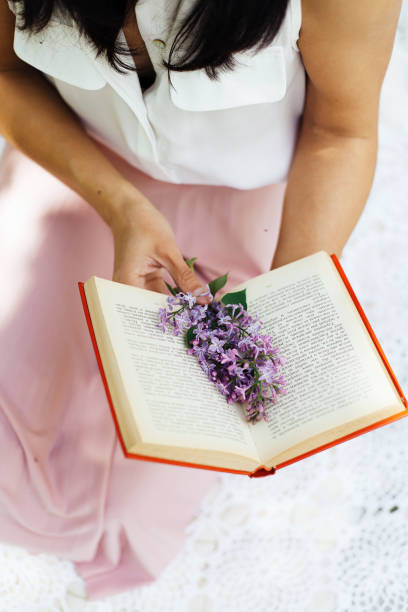 istock An open book with a lilac flower 2194349892