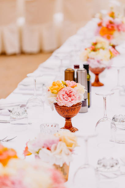Floral arrangement for celebration. A beautiful arrangement of pink and white roses adorns a table, enhancing the atmosphere of a festive gathering.