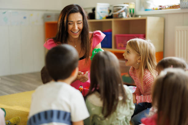 istock Woman having fun while playing with children in playroom 2194351925