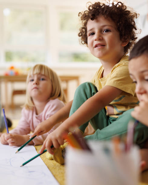 Children draw with crayons in kindergarten