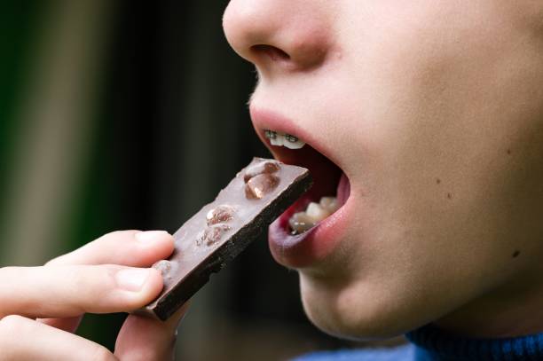 istock Child eating a piece of chocolate with nuts. 2194352374