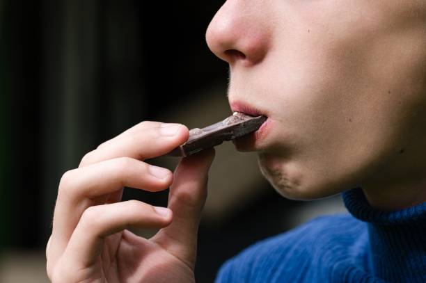 istock Person enjoying a piece of dark chocolate. 2194352388