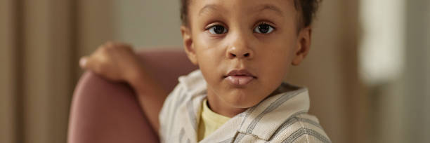 istock Header Image of Cute Black Boy Sitting in Chair Indoors 2194353387