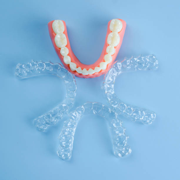 istock Close-up. Transparent aligners for artificial jaw teeth on a blue background 2194354043