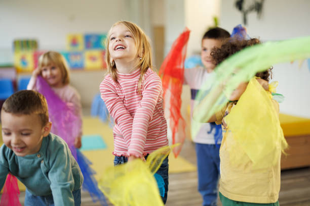 Children in kindergarten dance with scarves in their hands stock photo