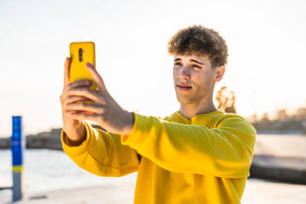 istock Young man taking a selfie on the beach 2194355128