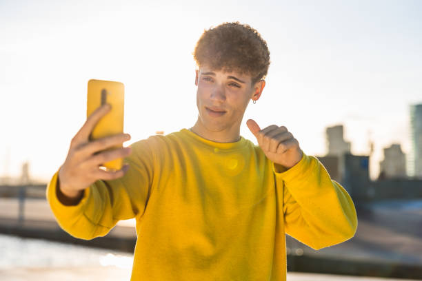 istock Young man taking a selfie while showing thumbs up sign 2194355149