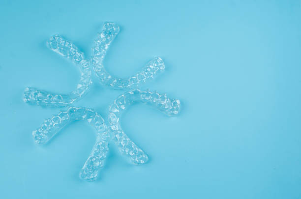 istock Invisible dental teeth brackets tooth aligners on blue background. Plastic braces dentistry retainers to straighten teeth. 2194355274