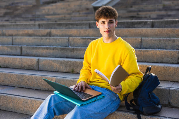 istock College student studying on university steps with laptop and book 2194355581