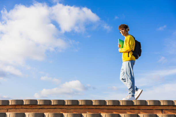 istock College student walking on campus with headphones and backpack 2194355718