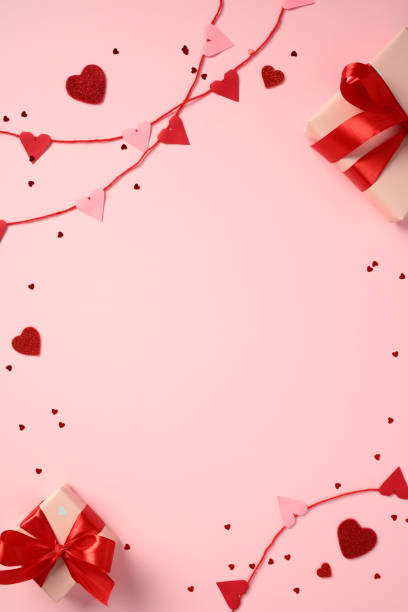 istock Happy Valentines Day concept. Flat lay red and pink heart decorations on string, and two gift boxes wrapped with red ribbons on pink background. 2194355829