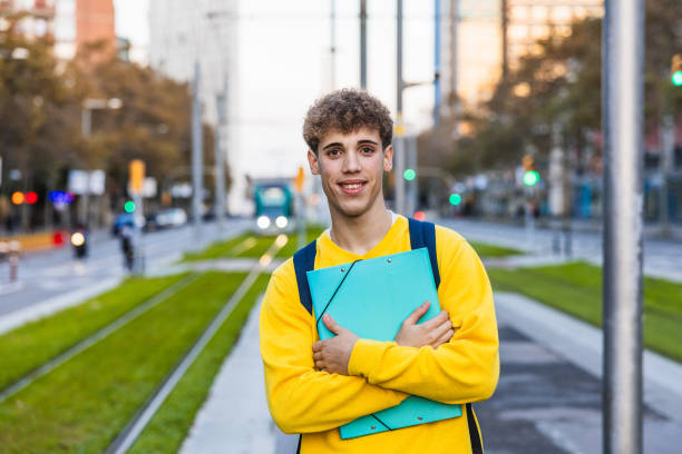 istock Smiling college student holding a binder in the city 2194355867