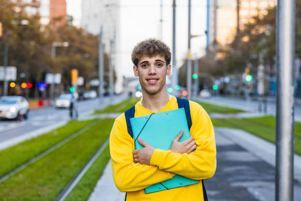 istock Smiling college student holding binder and backpack in city 2194355896