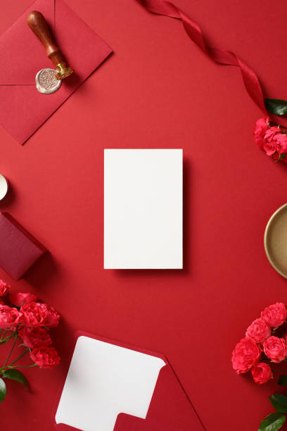 istock Wedding flat lay composition with blank white card, red envelope, wax seal, ribbon, roses, and gold dish 2194355982