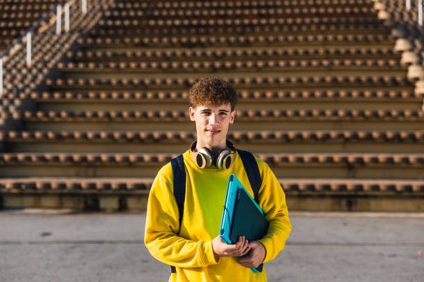 istock Smiling young college student holding books and looking at camera 2194356113