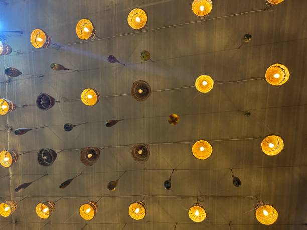 A ceiling adorned with numerous warm-toned light bulbs arranged in a symmetrical grid pattern, creating an elegant and contemporary lighting design. This design blends modern aesthetics with functionality, perfect for interior decoration or architectural inspiration.