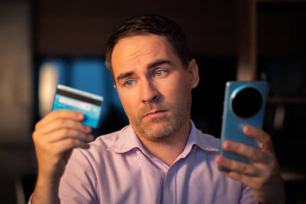 Online payment concept. Man using credit card with mobile phone at white background. Male hands holding smartphone with blank screen and reverse bank card. Person pays using mobile. Transaction. Online payment concept. Man using credit card with mobile phone at white background. Male hands holding smartphone with blank screen and reverse bank card. Person pays using mobile. Transaction cvc stock pictures, royalty-free photos & images