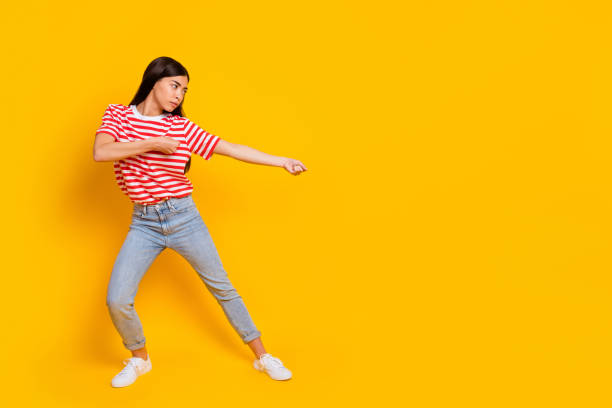 istock Full size profile portrait of confident concentrated girl look hands pull empty space isolated on yellow color background 2194358891
