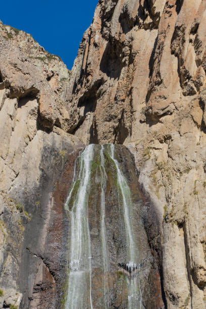 Foaming water falls from great height against backdrop of unique mountain range. Famous Abai-Su waterfall is two streams flying down steep cliff 72 m high. Kabardino-Balkaria. Chegemsky Reserve 2024.