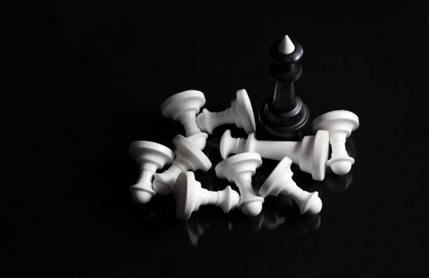 Chess pieces. Black chess king. White chess pieces is defeated. Evil triumphs over good