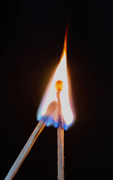 istock two burning matchsticks with intertwined flames against a black background, symbolizing connection, passion, and the fleeting nature of fire 2194365774